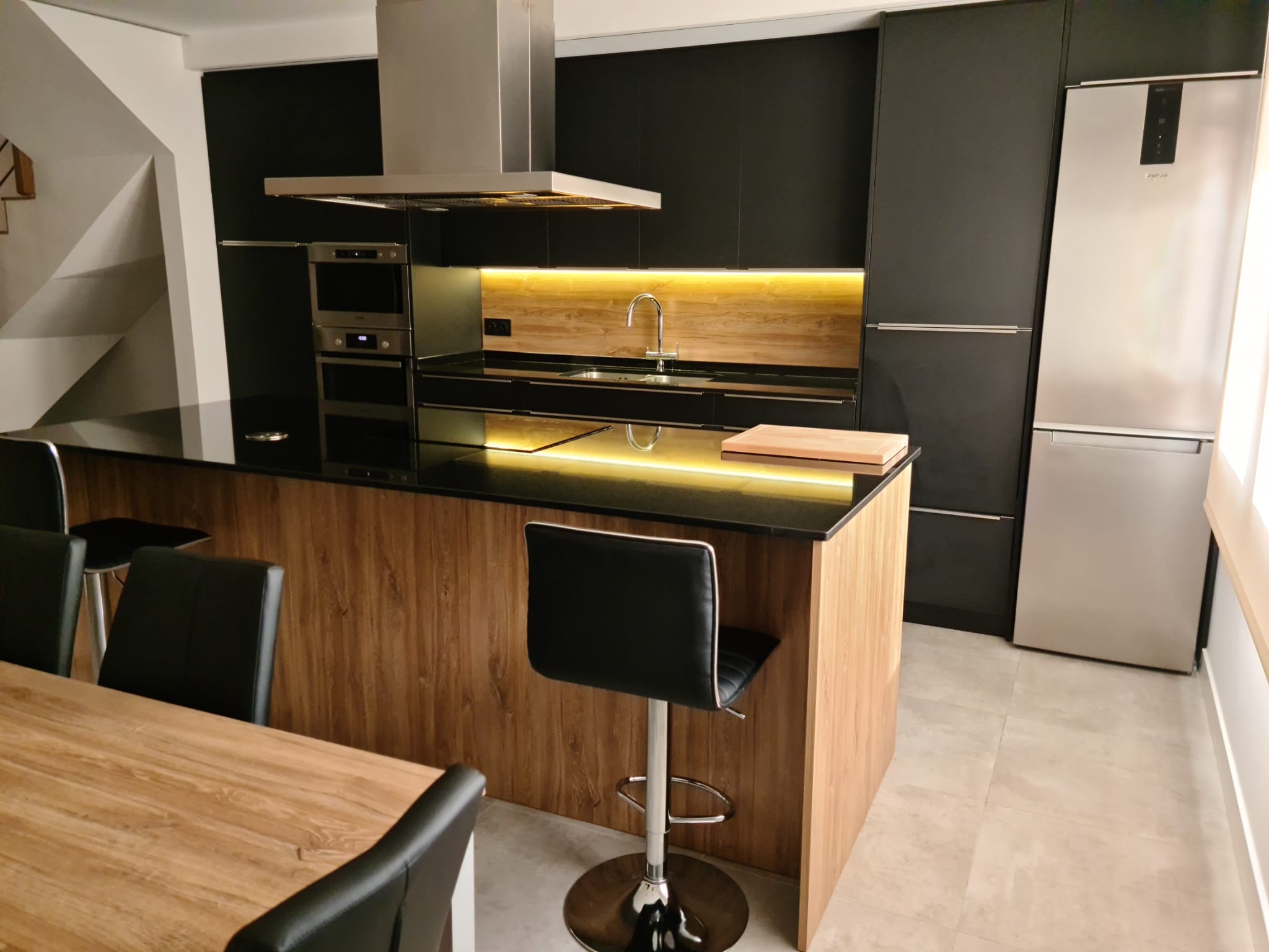 Ambiente Whirlpool negro y roble en esta cocina de Casals